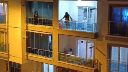 Sinir krizi geçiren genç kadın balkonundaki eşyaları yola fırlattı